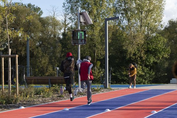 Dos corredores en la pista de atletismo en Saint-Dizier, con un radar pedagógico EVOLIS Vision mostrando una velocitad de 17km/h